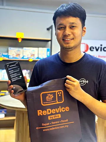 Customer holding a ReDevice bag and a phone in the store