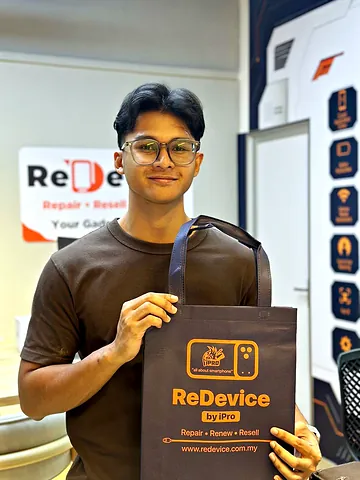 Customer in a brown T-shirt holding a ReDevice bag