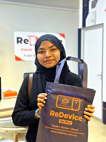 Customer in a black hijab holding a ReDevice bag