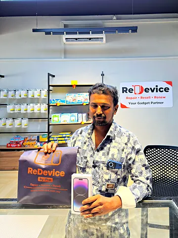 Customer with an iPhone box and a ReDevice bag at the counter