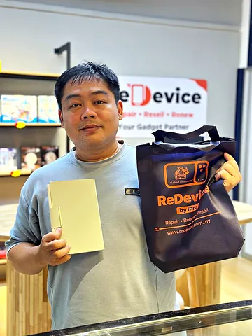 Customer holding a ReDevice bag and a tablet at the counter