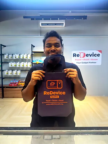 Customer holding a ReDevice bag in front of the accessory shelves
