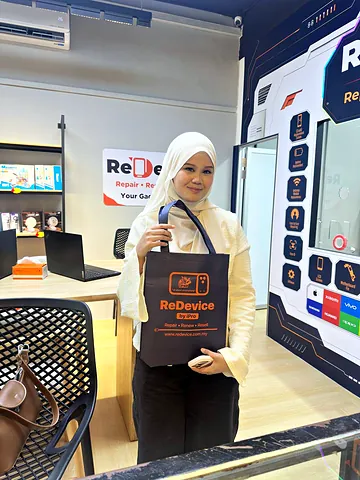 Customer in a white hijab holding a ReDevice bag in the store