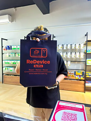 Customer holding a ReDevice bag up at the counter